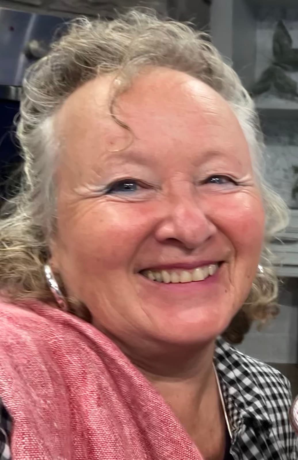 Susan Lachmann smiling, in a pink scarf